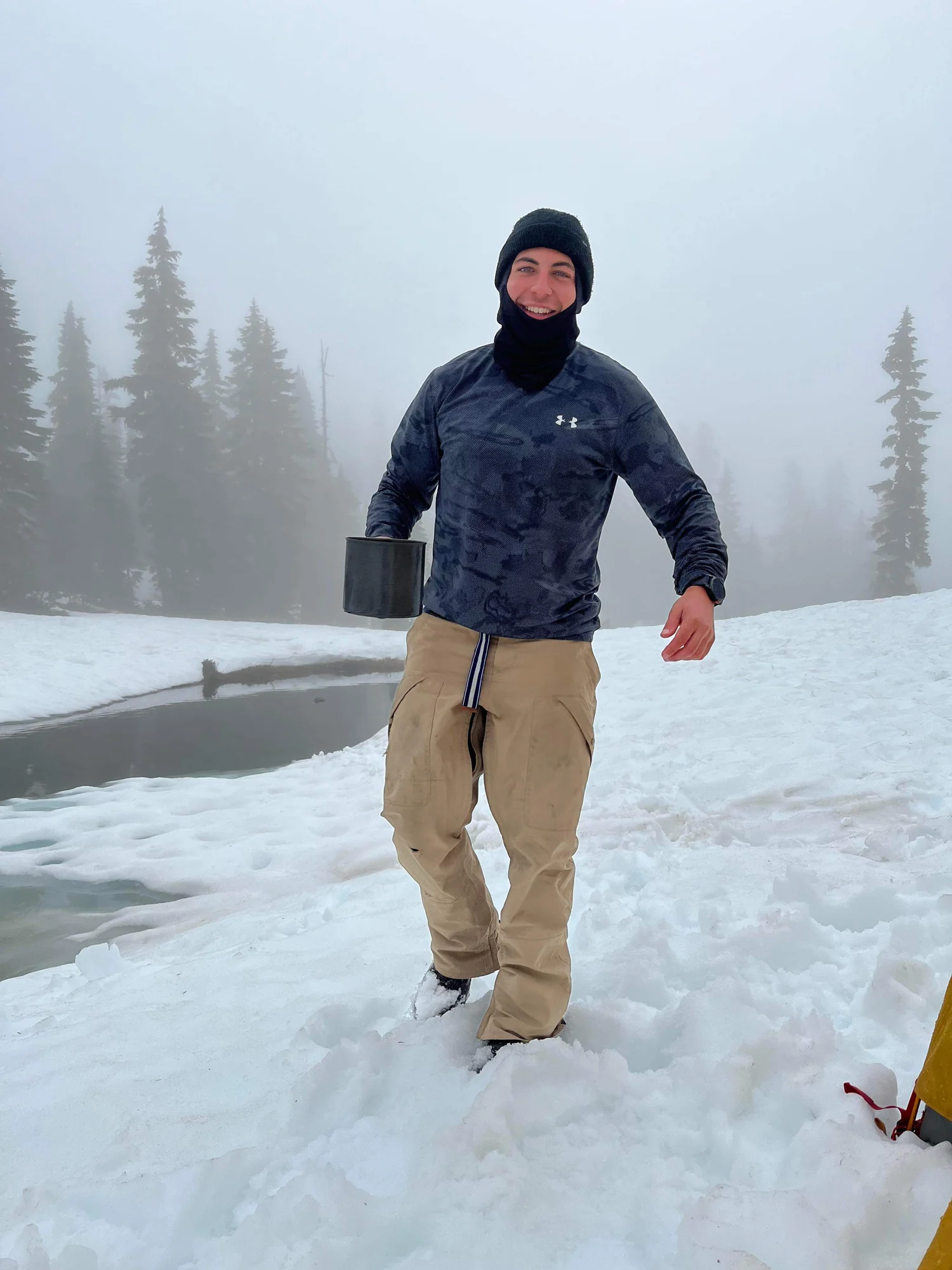 Jakeob holding a mug in a snowy forest